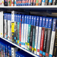 A shelf lined with a bunch of physical copies of video games.
